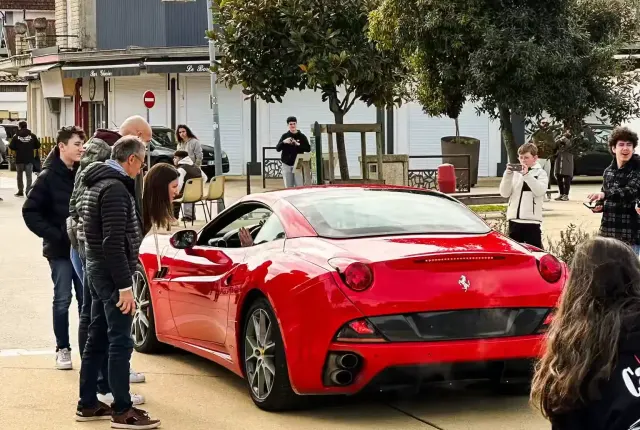 Ferrari rouge et passionnés au Paddock